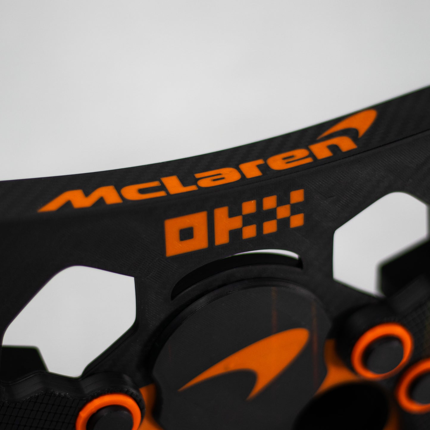 Detalle de los botones y logo de McLaren Racing en mod de volante oscuro