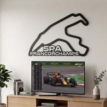 Silueta del circuito de F1 de Spa-Francorchamps en relieve negro mate decorando la pared sobre un televisor