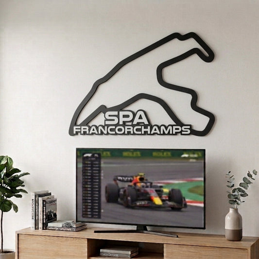 Silueta del circuito de F1 de Spa-Francorchamps en relieve negro mate decorando la pared sobre un televisor
